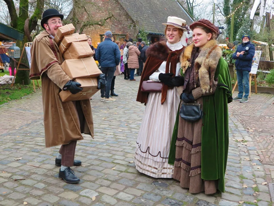 Figuranten in kleding uit de tijd van Anton Pieck wandelen tussen de bezoekers tijdens het Eynder Pieck Festeyn.