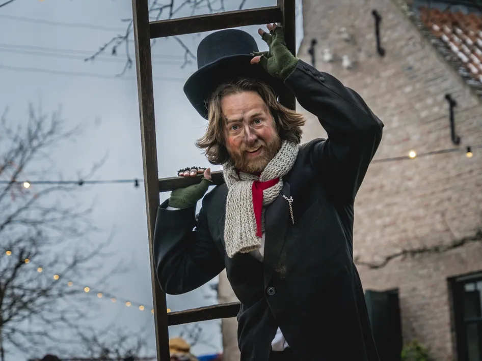 Figurant in Anton Pieck-stijl met hoge hoed en ladder tijdens het Eynder Pieck Festeyn in openluchtmuseum Eynderhoof.