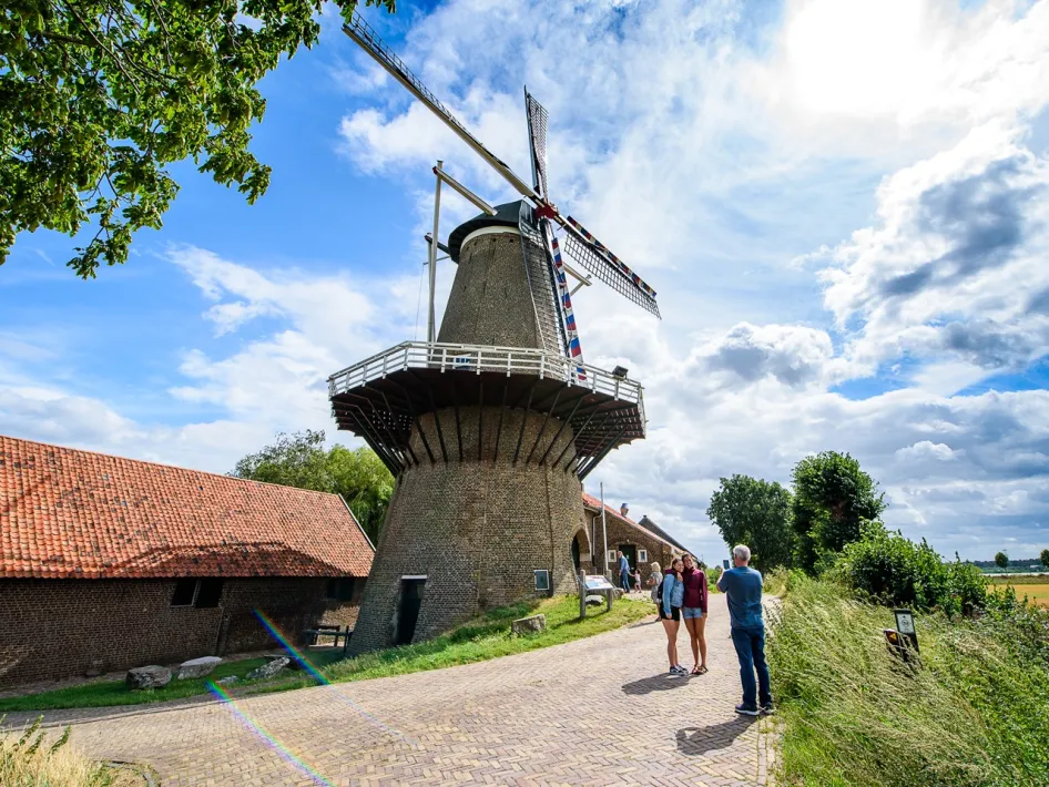 Bezoekers bij de Hompesche Molen aan de rand van het Maaslandschap