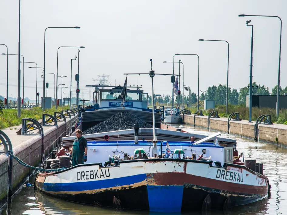 Binnenvaartschip vaart door de sluis van Maasbracht, een opvallend punt langs de Maasstadjestour.