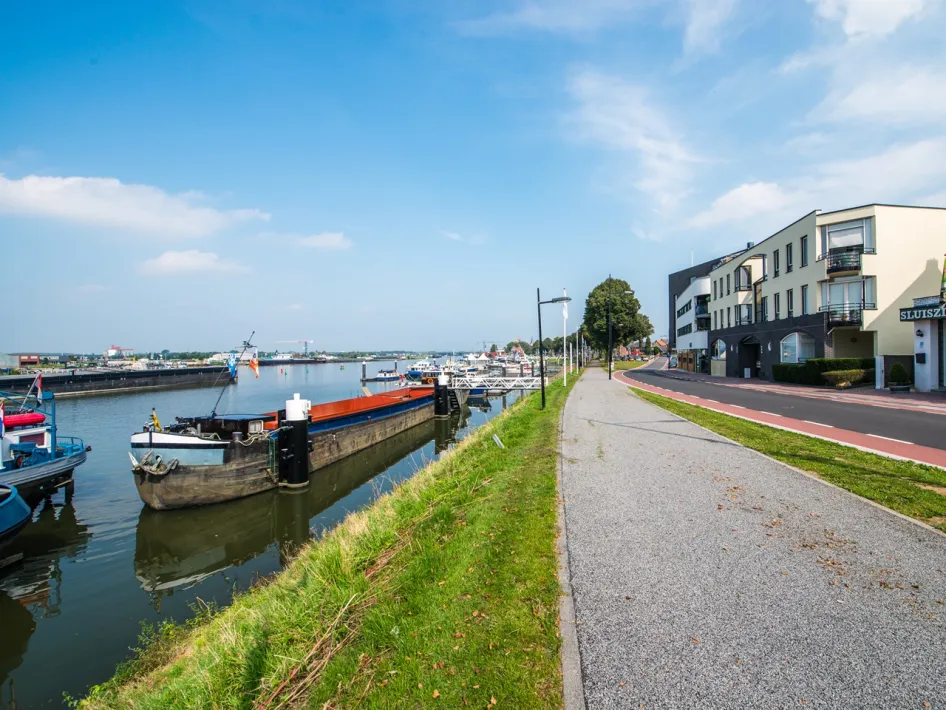 Haven van Maasbracht met binnenvaartschepen, kade en fiets- en wandelpad langs het water.