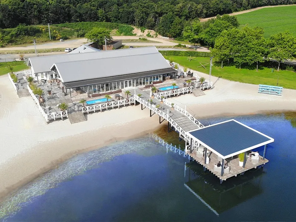 Luchtfoto van Beachclub Degreez met terras, strand en aanlegsteiger aan het water.