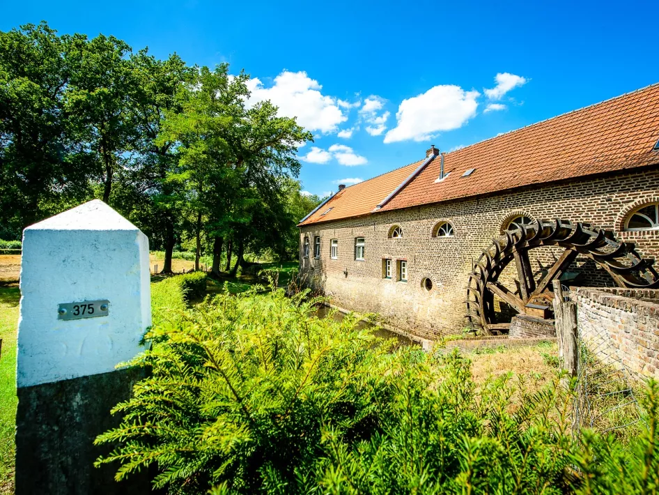 De Gitstappermolen met op de voorgrond een grenspaal langs de wandeling Rothenbach - Vlodrop Station