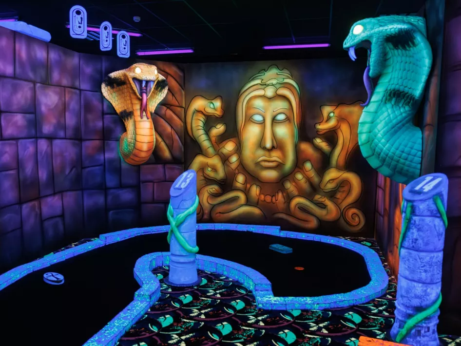 Hole 13 at Glowgolf Weert. A blacklight snake at a Mayan culture-inspired minigolf course