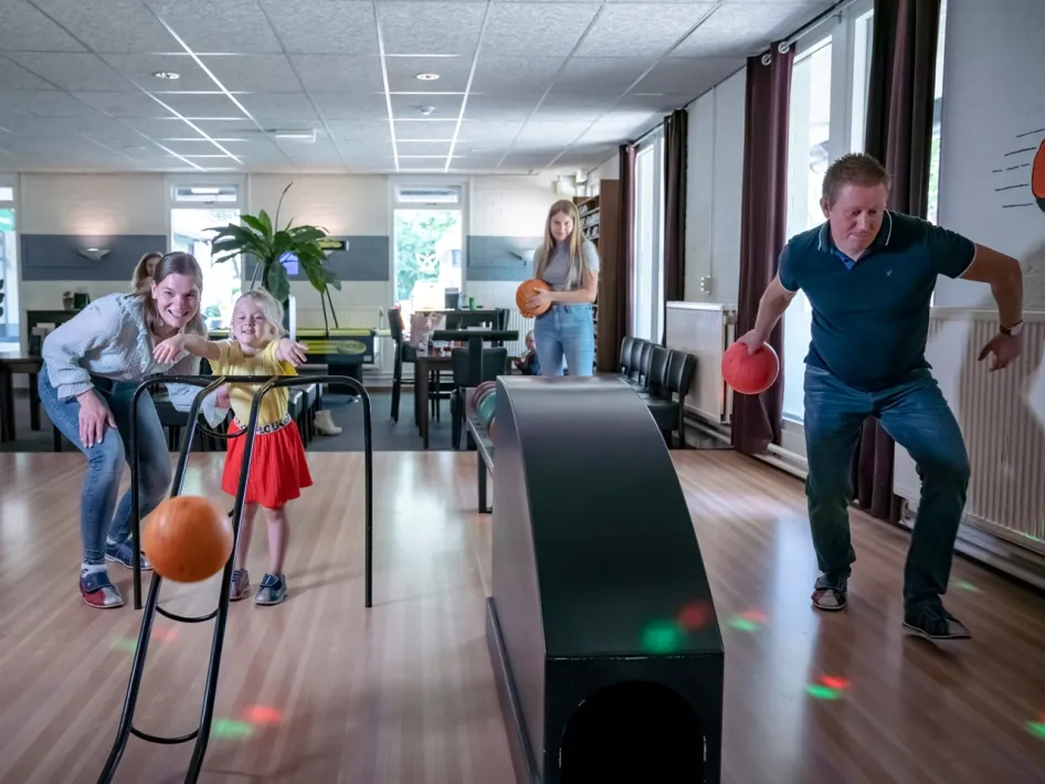A family plays together on the bowling lane at Grand Café Pimpernel.