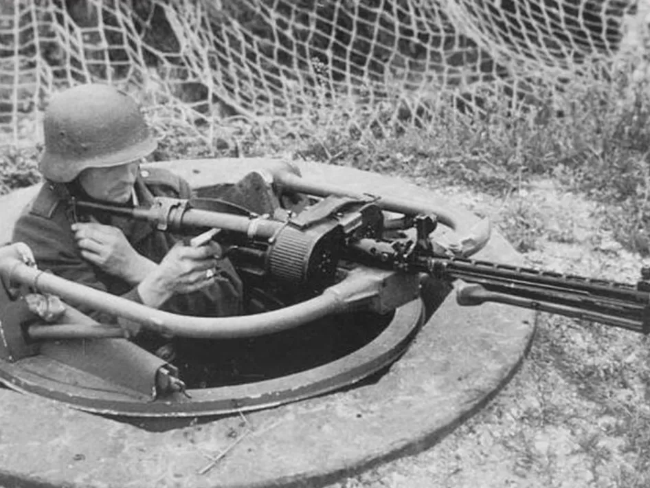 Duitse soldaat in een Tobruk bunker met mitrailleur, onderdeel van de verdedigingslinie rond Swalmen in WOII.