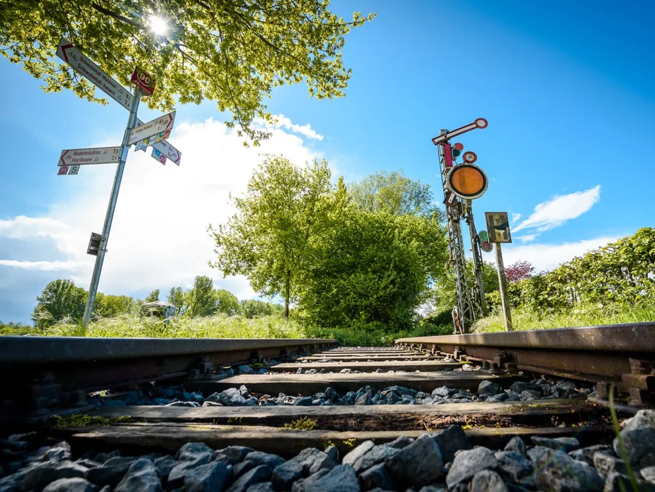 Historic railway line with old-fashioned signals and route markers in Brüggen, part of the cross-border cycling route Grenzgeschichten Reuver-Brüggen.