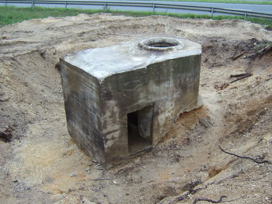 Betonelement eines Bunkers aus dem Zweiten Weltkrieg, teilweise im Boden eingegraben entlang des ehemaligen Panzergrabens bei Reuver.