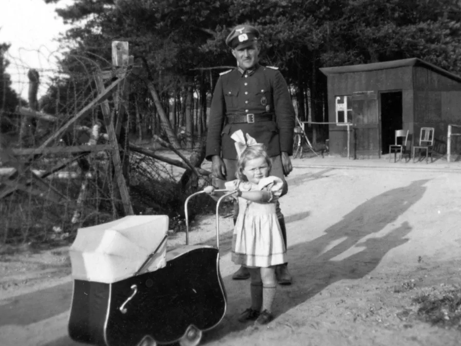 Duitse soldaat en jong meisje met kinderwagen aan een grensovergang in de buurt van de Westwall, gefotografeerd tijdens de oorlogsjaren.