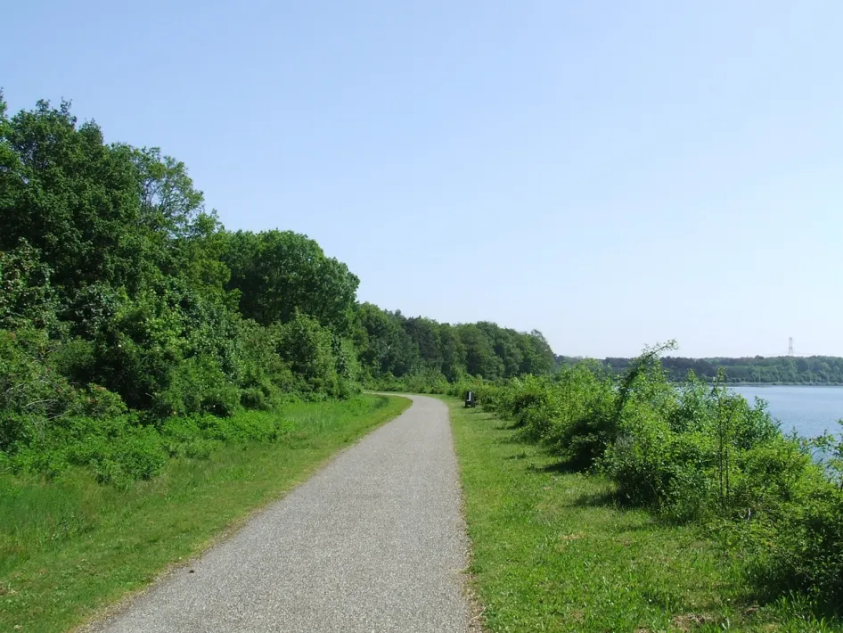 Walking path along greenery and water of the Maas Lakes during the Grindgatenroute