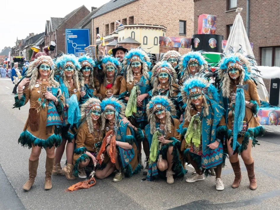 Feestelijk verklede groep deelnemers poseert tijdens de Halfvastenoptocht in Maaseik.