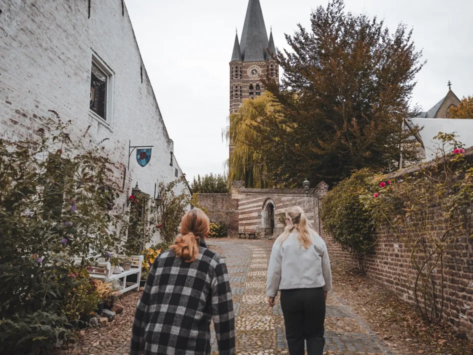 Wandelaars lopen door de historische straten van Thorn tijdens Het Wilde Vrouwenpad.