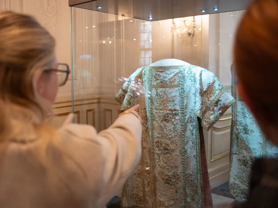 Bezoeker bekijkt een historisch gewaad in een vitrine van de Abdijkerk in Thorn