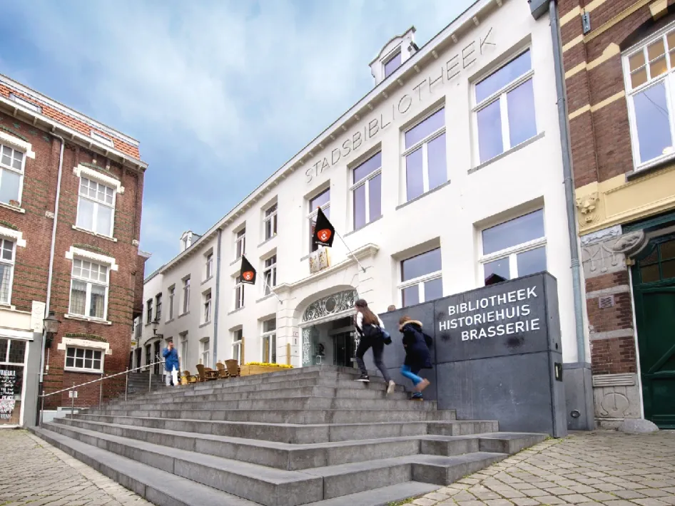 Hoofdingang van het Historiehuis Roermond met bezoekers op de trap voor de bibliotheek.