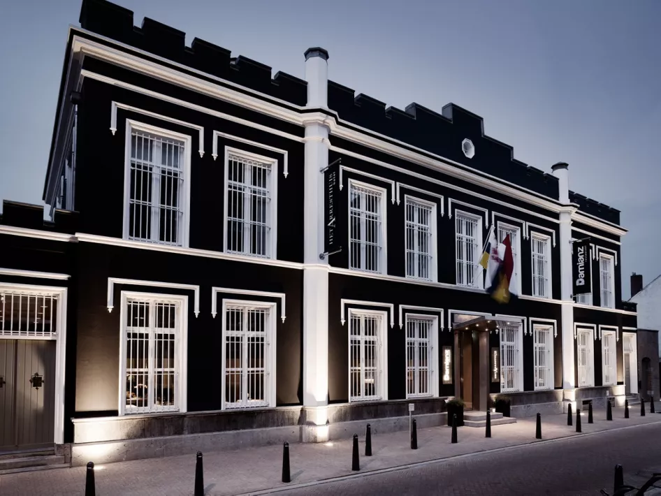 Außenansicht des The Arrest House in Roermond, einem ehemaligen Gefängnis, das in ein luxuriöses Fünf-Sterne-Hotel umgewandelt wurde, mit einer auffälligen schwarz-weißen Fassade und historischer Architektur.