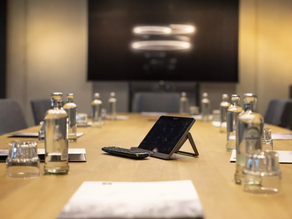 Besprechungsraum mit Getränken in Flaschen und Großbildschirm im Hintergrund