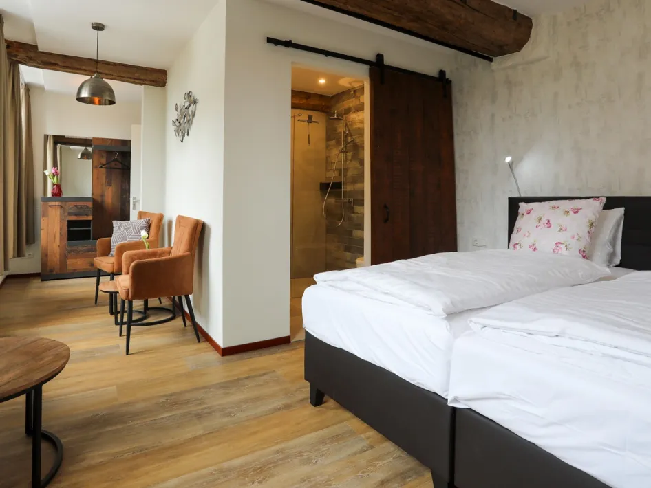 Comfortable hotel room with a double bed, seating area and modern bathroom.