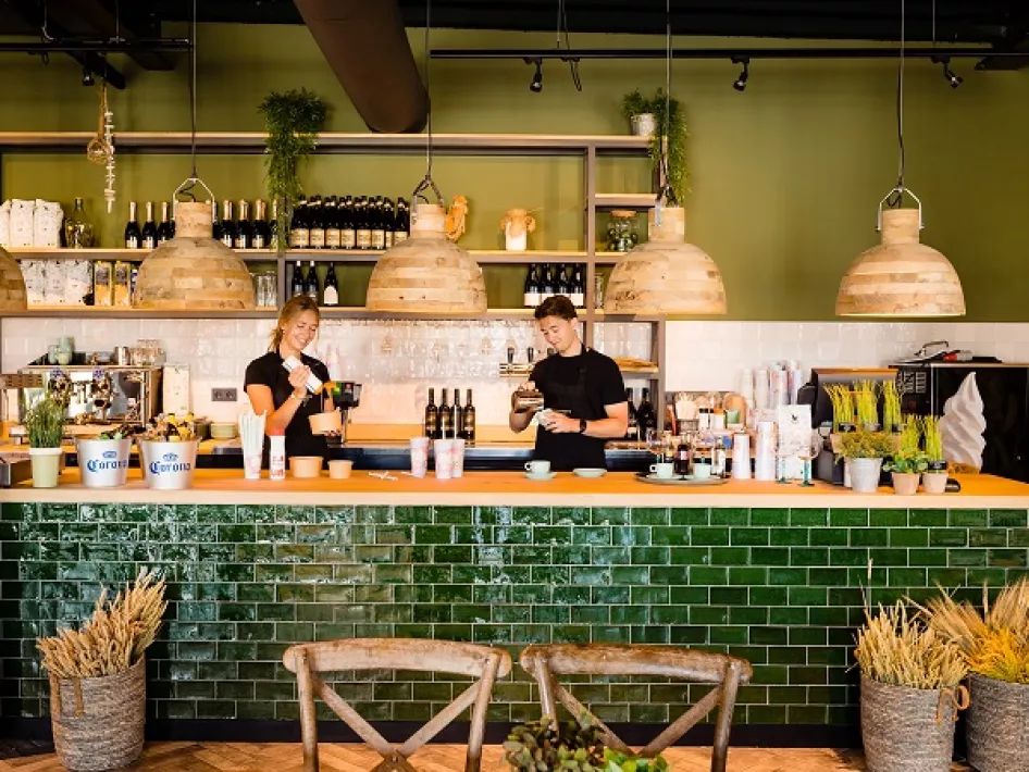 De barkeeper en de barista aan het werk achter de bar