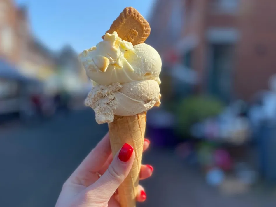 Hand holding a cone filled with artisanal ice cream at Wijs en Koffie.