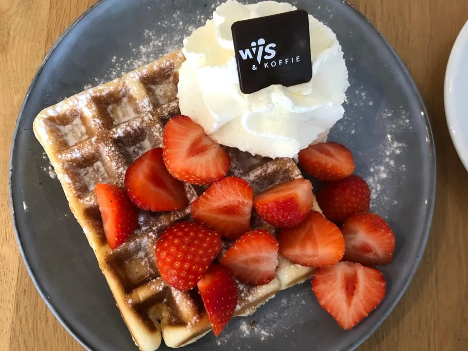 Homemade waffle with strawberries and whipped cream at Wijs en Koffie.