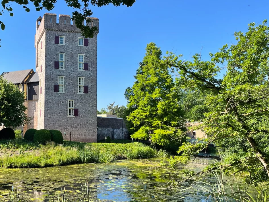 De kasteeltoren van Kasteel Daelenbroeck aan het water op een zonnige dag