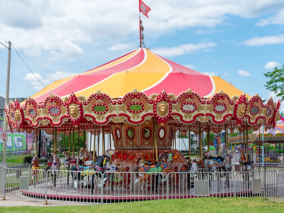 Kleurrijke draaimolen op de Kermis Ospel onder een blauwe lucht.