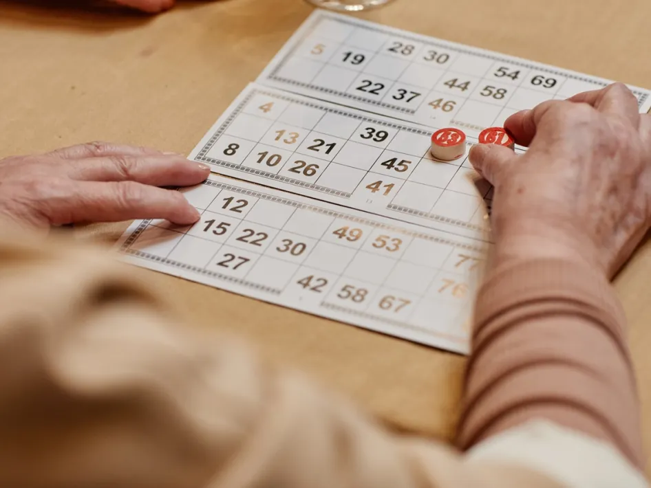 Persoon houdt een kaart vast tijdens Vastelaovend Kienen in Merum.