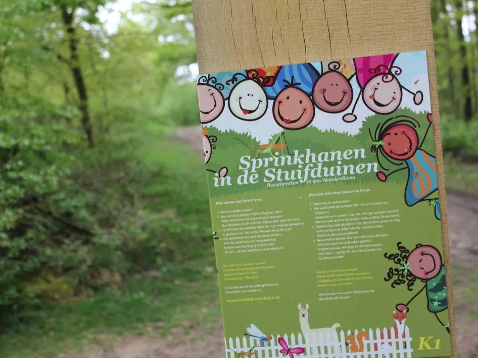 Bord van Kindergeluksplek 1 Snelle sprinkhanen in de Stuifduinen die je tegenkomt tijdens de Gelukswandeling De statige bomen van het Rozendaal