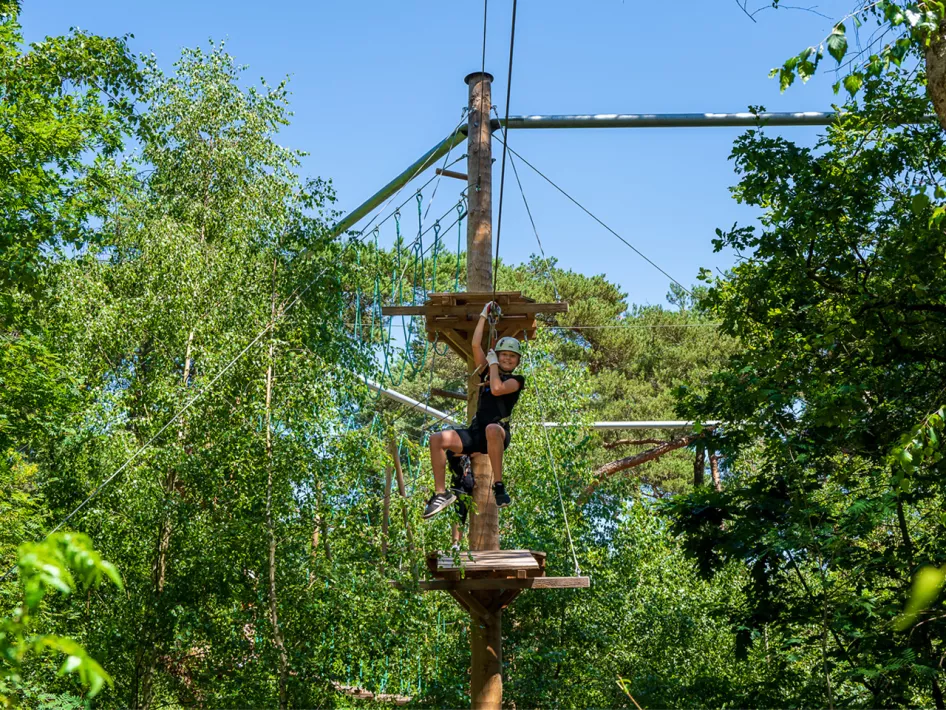 Meisje is aan het klimmen in het klimbos in Weert