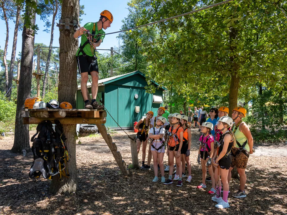 instructeur geeft uitleg aan een groep kinderen over het klimmen in hetklimbos