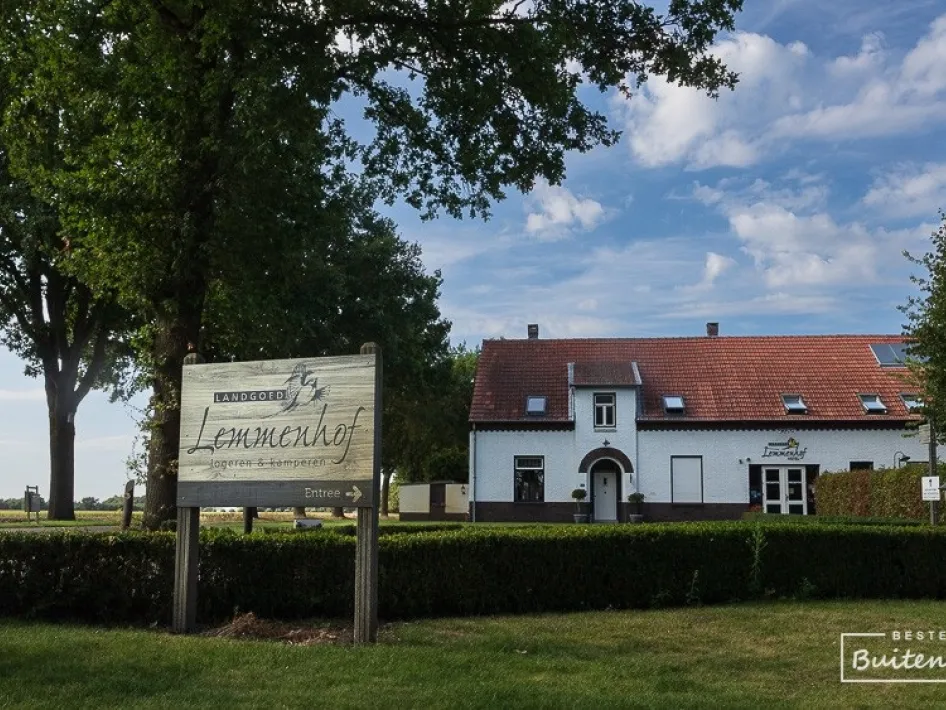 Front view of accommodation n the Limburg landscape with sign and green surroundings.
