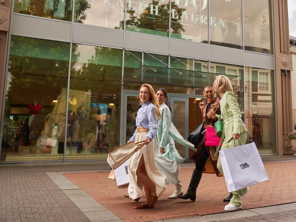 Vier Frauen mit Einkaufstüten vor Ralph Lauren beim Late Night Shopping im Designer Outlet Roermond.