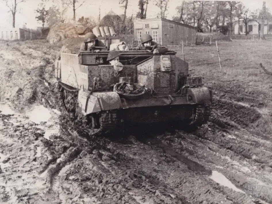 Geallieerde militairen in een klein pantservoertuig rijden door een modderige weg in het frontgebied bij Thorn.
