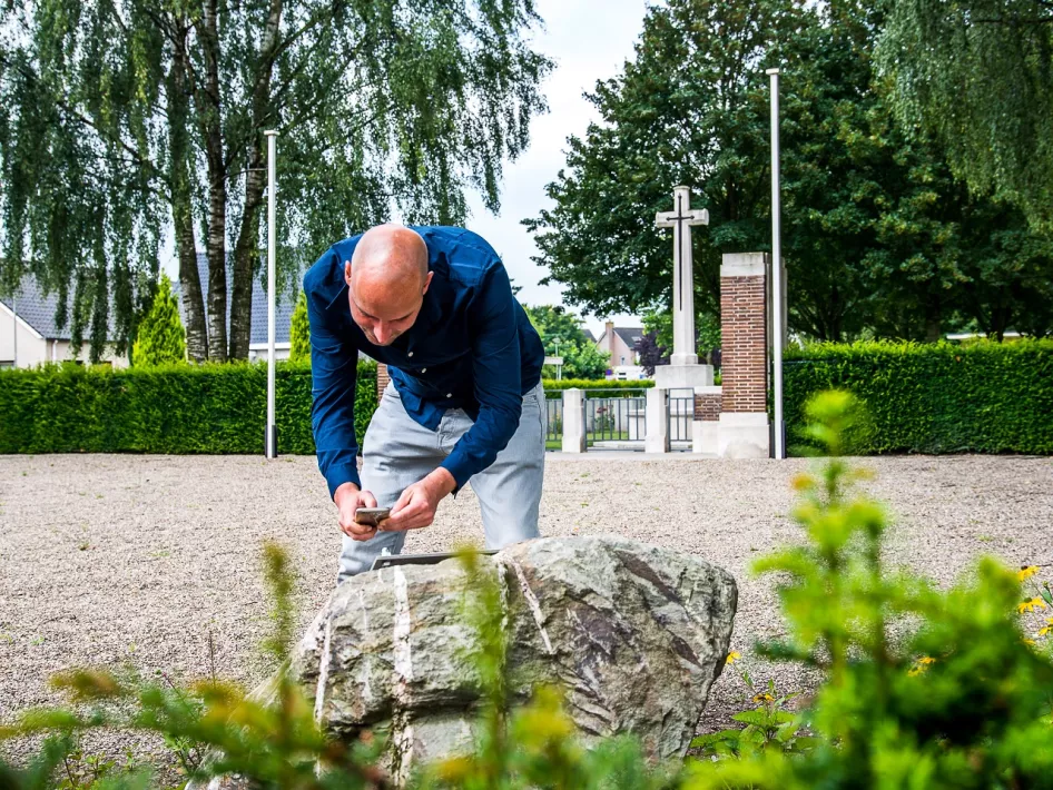 Mann scannt Code am Hörstelle der Liberation Route in Nederweert