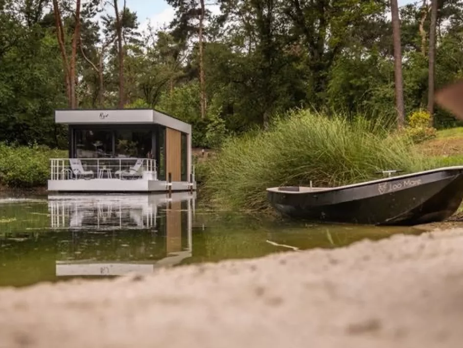 Het drijvend vakantiehuisje van Loo Mare met op de voorgrond een roeibootje