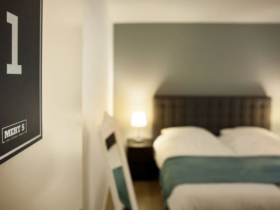 Gemütliches Schlafzimmer im MERT 5 mit Doppelbett und Nachttischlampen.