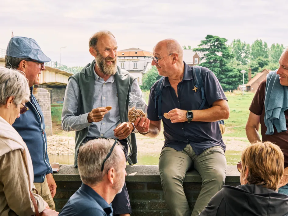 Een korte stop aan de Maas, met een lekker hapje en drankje tijdens de Aperitiefwandeling in Maaseik