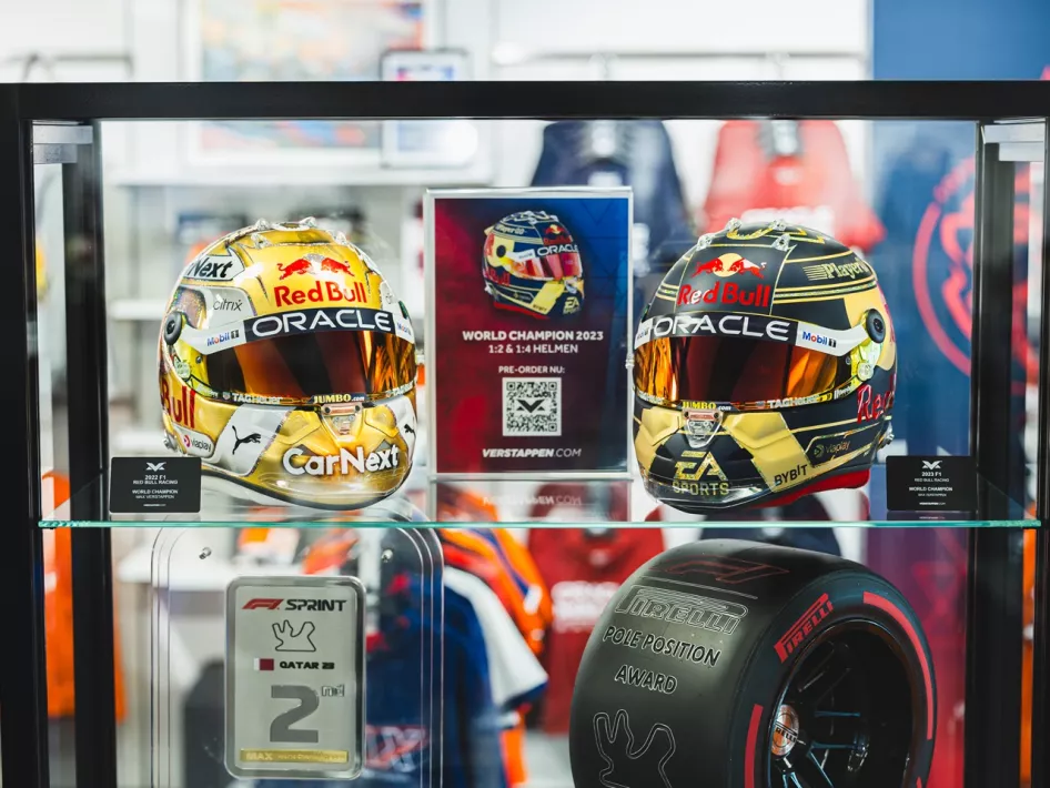 Twee helmen van Max tentoongesteld in een vitrine in de Max Verstappen Store
