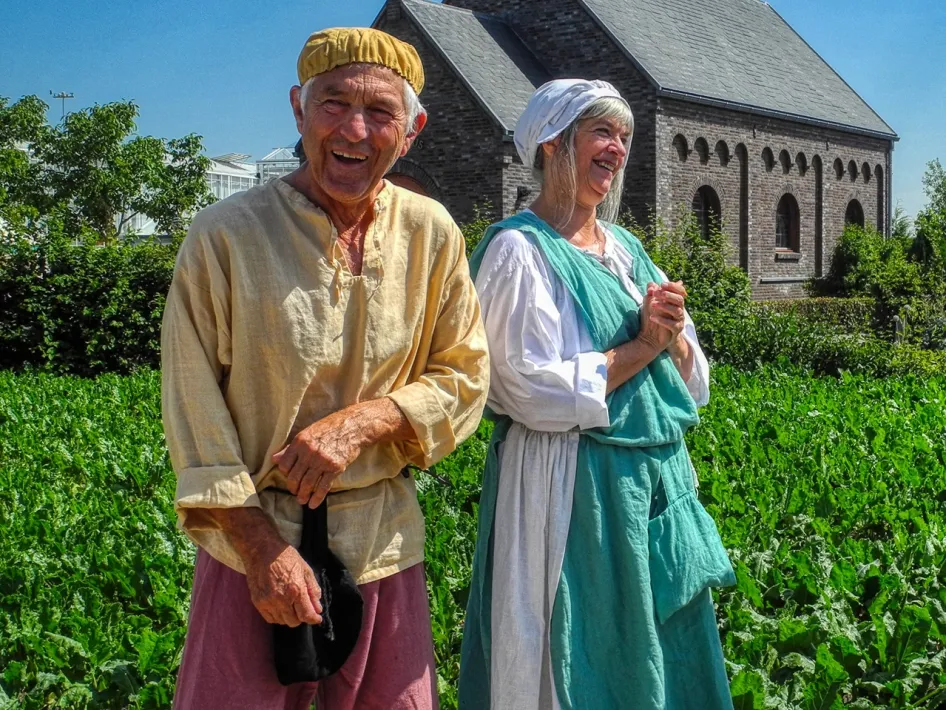 Bezoekers in middeleeuwse kleding staan voor een historische boerderij tijdens het Middeleeuws Weekend bij Museumdorp De Locht in Melderslo.