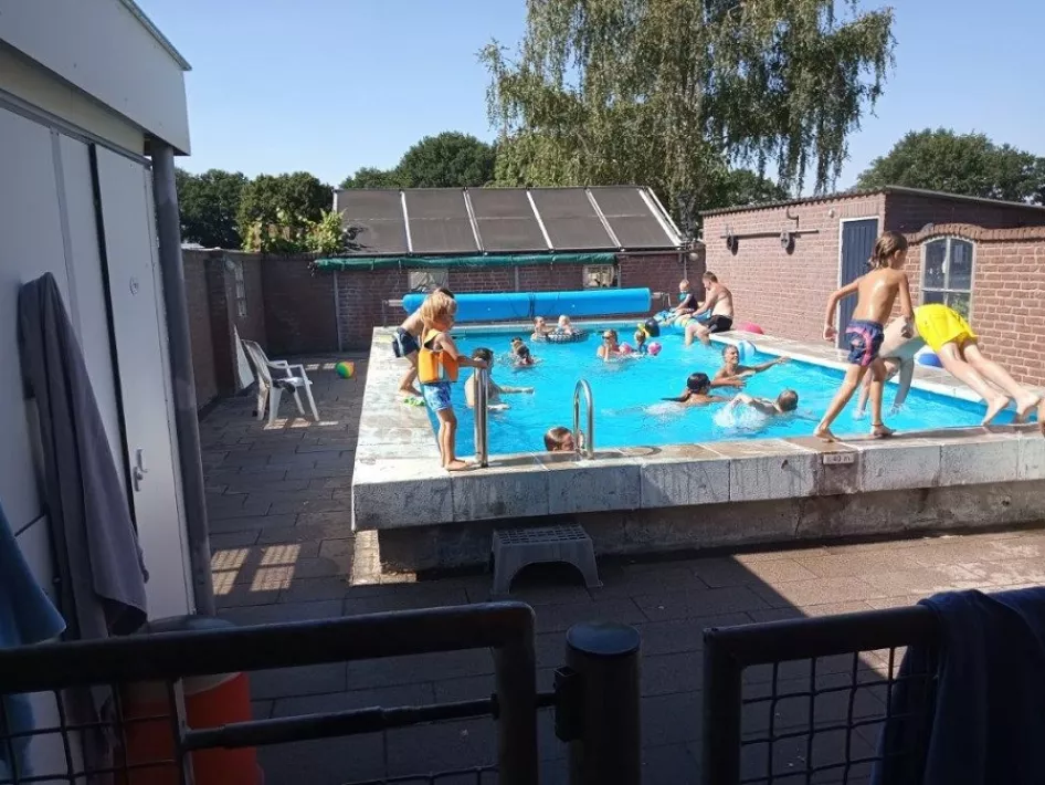 Kinderen zwemmen en duiken in het zwembad