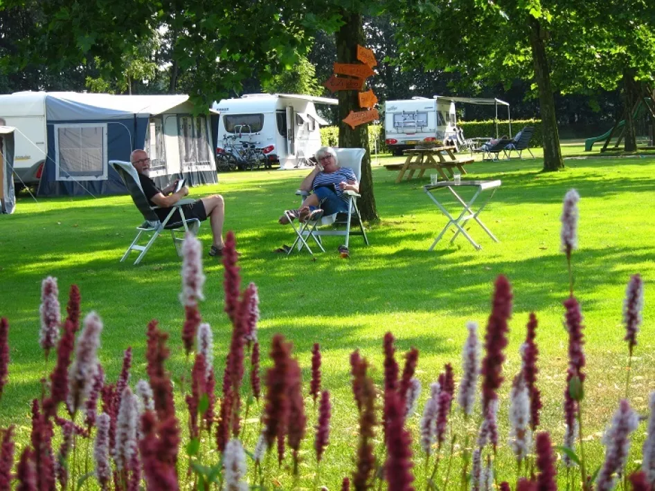 Campinggasten relaxen in de schaduw op het trekkersveld ven de Linde