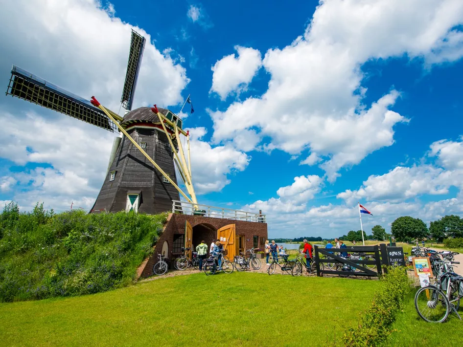 Radfahrer halten am Grauwe Beer, um im Mühlenladen lokale Produkte zu kaufen