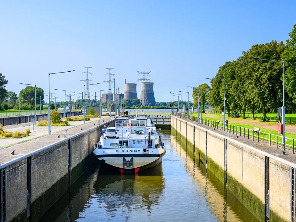 Cargo ship in Sluis Osen with industry and power lines in the background