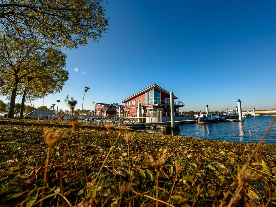 Marina in Wessem with jetties, boats and buildings by the water