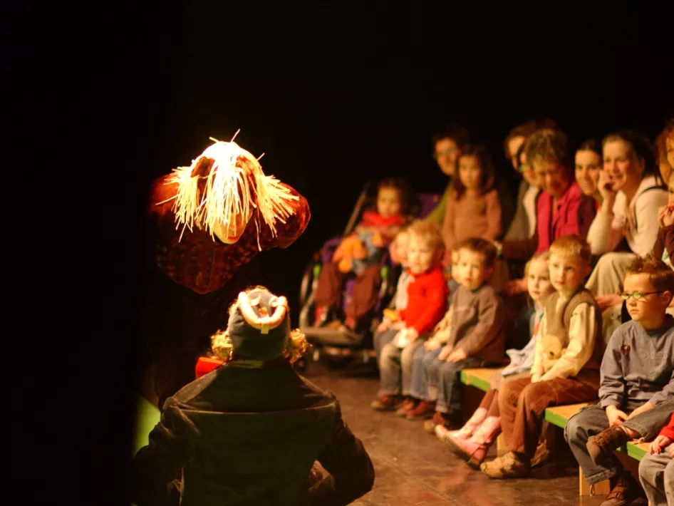 Kinderen luisteren aandachtig naar een toneelstukje 