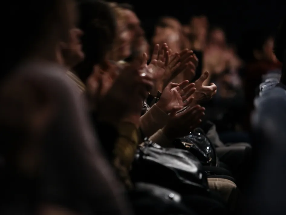 Publiek applaudisseert na een uitvoering tijdens Muziek voor de Vespers in een kerkelijke setting.