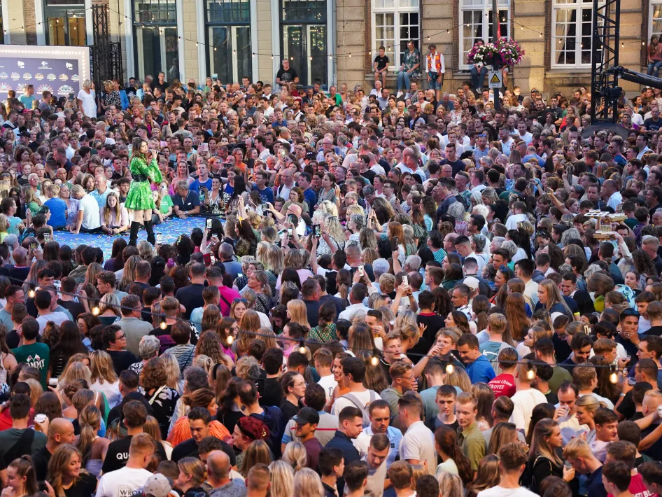 Drukke menigte voor het podium tijdens Piraten op het Plein Neer 2026, met een zangeres in het midden van het plein.