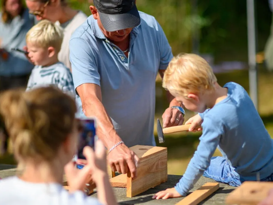 Kind timmert samen met een volwassene een nestkastje tijdens de workshop nestkastje timmeren in Nationaal Park De Groote Peel.