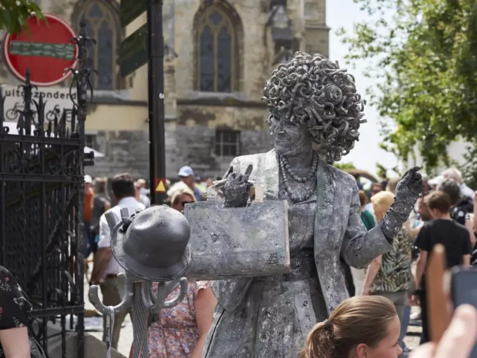 Levende standbeelden Thorn: een act met een vrouw als standbeeld met schildersezel, omringd door publiek in het centrum van Thorn.