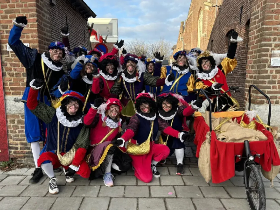 Pieten tijdens een Sinterklaasviering, poserend buiten bij een bakfiets.
